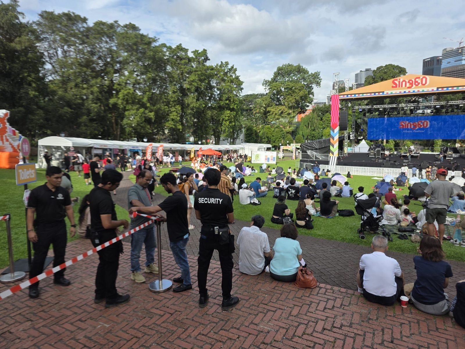 Hawkeye officers holding a perimeter line at an outdoor Singapore festival